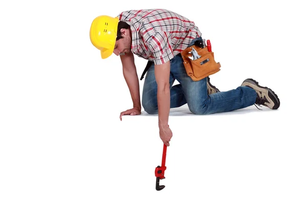 Εργαζόμενος φθάνει κάτω με ένα γαλλικό κλειδί — Φωτογραφία Αρχείου