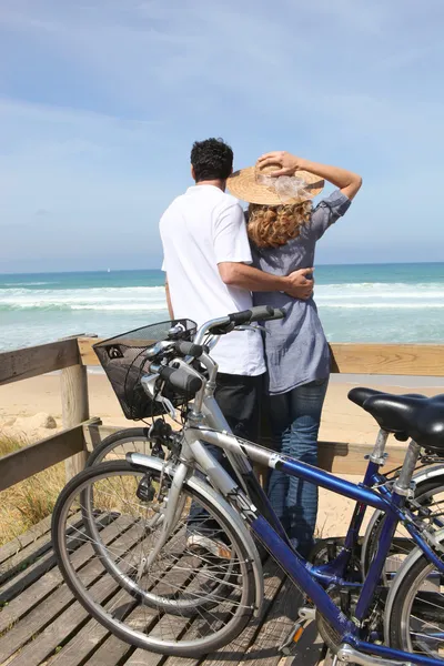 Пара с велосипедами у моря — стоковое фото