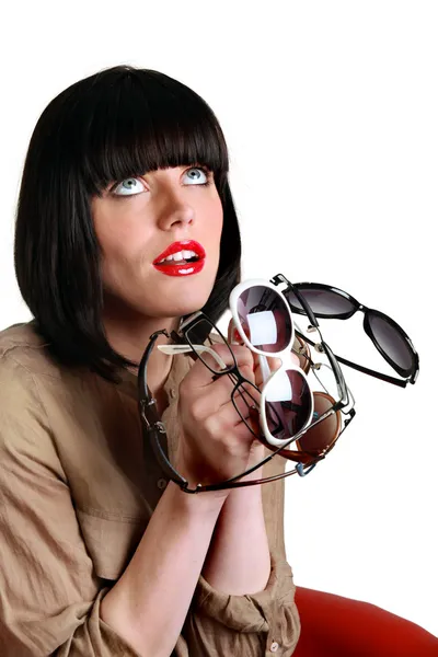 Woman holding several pairs of sunglasses — Stock Photo, Image