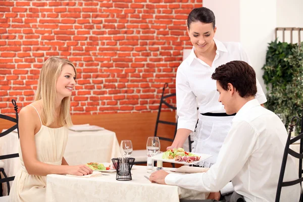品尝一对年轻夫妇在一家餐馆的女服务员 — 图库照片