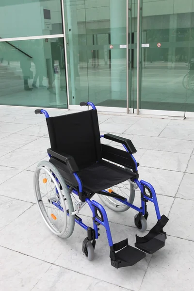 Пустое инвалидное кресло снаружи офисного здания — стоковое фото