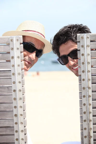 Senior und junger Mann entspannen sich am Strand — Stockfoto