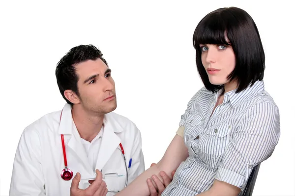Arts knielen door een vrouwelijke patiënt — Stockfoto