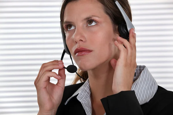 Brunette call-center worker adjusting head-set — Stock Photo, Image