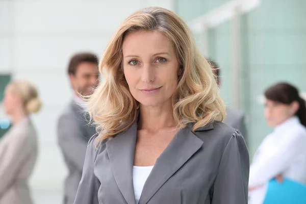 Woman standing in front of her colleagues — Stock Photo, Image