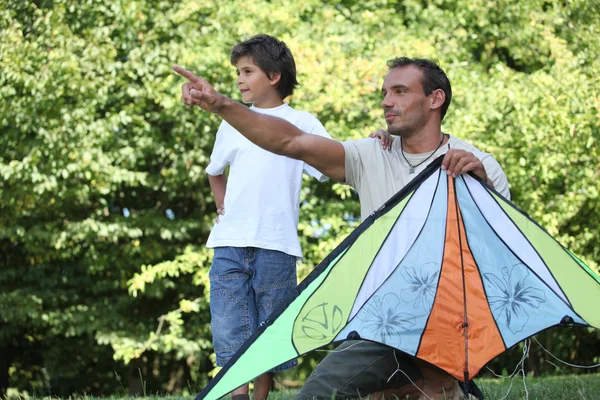 Отец и сын запускают воздушного змея — стоковое фото
