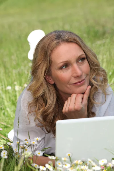 Frau auf Laptop im Feld — Stockfoto
