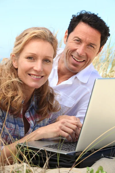 Ζευγάρι που είναι χαμογελώντας σε φορητό υπολογιστή. — Φωτογραφία Αρχείου
