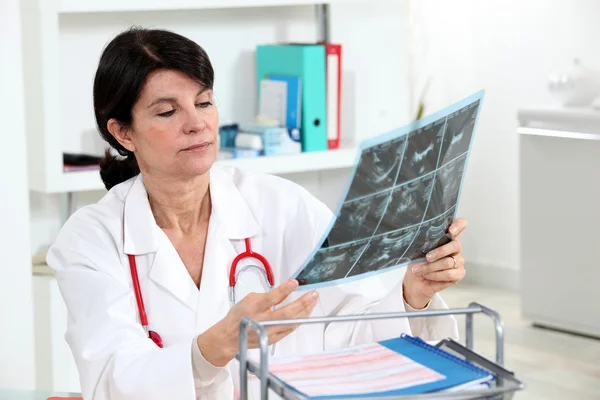 Um médico examinando uma radiografia . — Fotografia de Stock