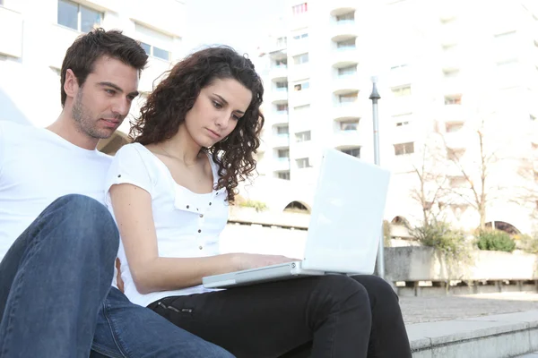 Casal usando computador portátil ao ar livre — Fotografia de Stock