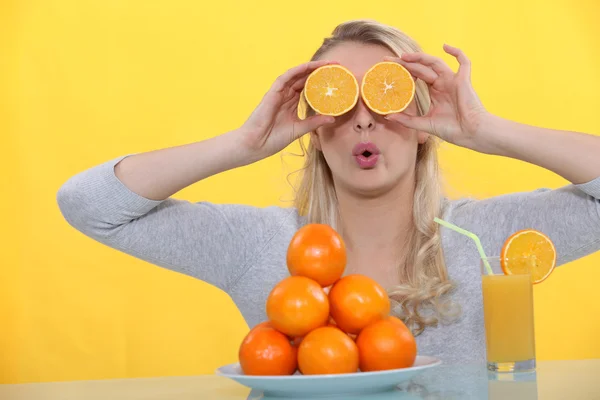 Женщина играет с апельсинами — стоковое фото