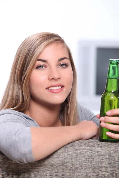 Jeune femme avec une bouteille de bière — Photo