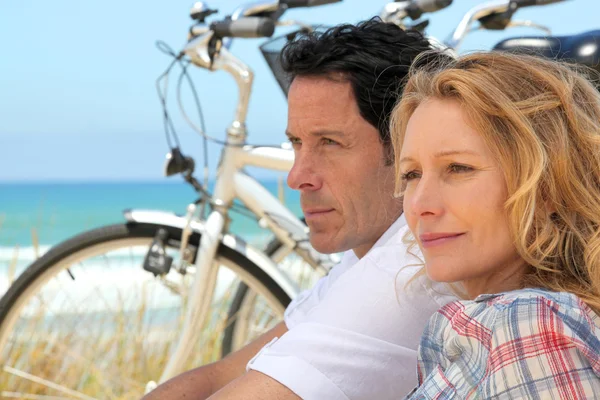 Couple with bicycles by the coast — Stock Photo, Image