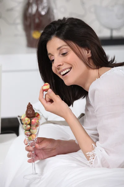 Cheerful woman eating Easter eggs — Stock Photo, Image