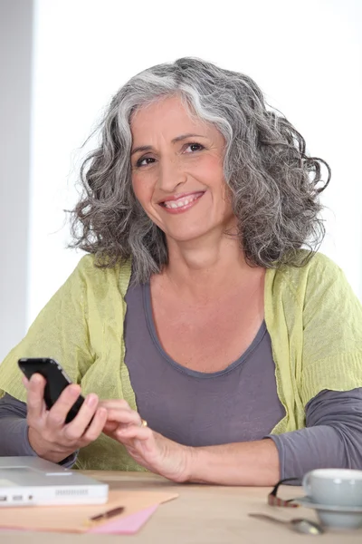 Ηλικιωμένη γυναίκα χρησιμοποιώντας ένα κινητό τηλέφωνο — Φωτογραφία Αρχείου