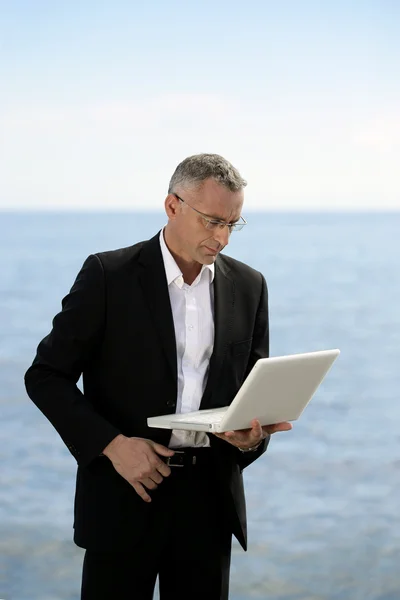 Homme d'affaires avec ordinateur portable se tenait près du lac — Photo