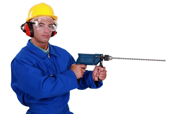 Artigiano con paraorecchie e occhiali protettivi con trapano elettrico — Foto Stock