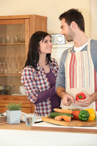 Young couple smiling in kitchen — Stok fotoğraf