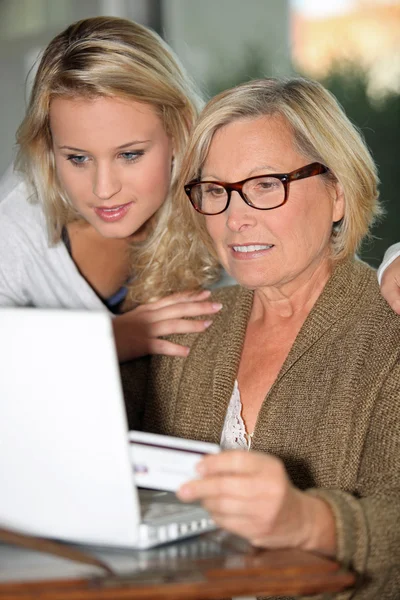 Abuela con nieta pagando en línea — Foto de Stock
