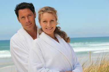 Couple in robes on the beach clipart