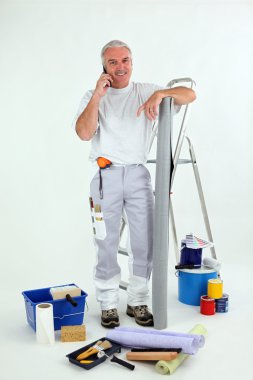 Grey-haired decorator making telephone call clipart