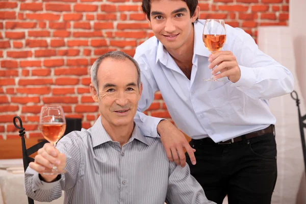 Homens levantando seus copos em um brinde — Fotografia de Stock