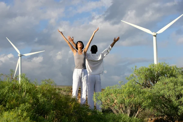 Couple s'étirant près des éoliennes — Photo