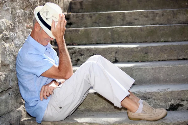 Starszy mężczyzna siedzi na niektóre kamienne schody — Zdjęcie stockowe