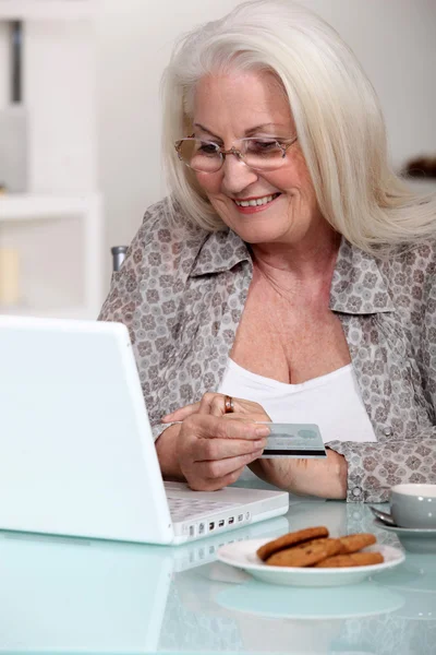 Пожилая дама делает покупки в Интернете — стоковое фото