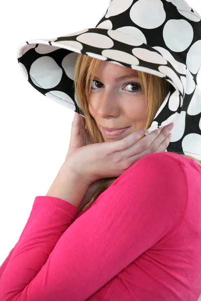 Застенчивая девушка в пунктирной шляпе — стоковое фото