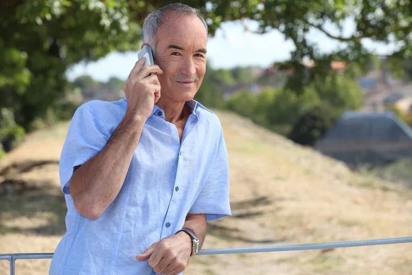 Siwy mężczyzna Dokonywanie telefon w parku — Zdjęcie stockowe