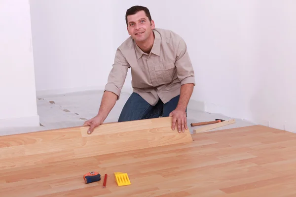 Muž instalující laminátové podlahy — Stock fotografie
