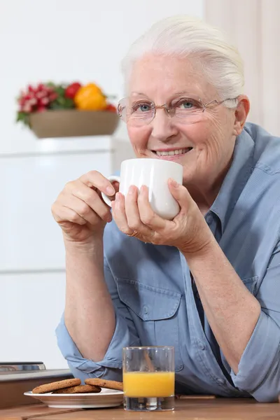Starší dáma se těší šálek čaje — Stock fotografie
