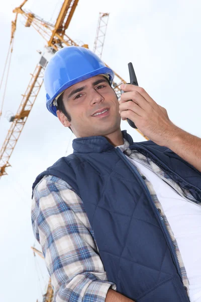Foreman in front of a crane, low-angle shot — Stock Photo, Image