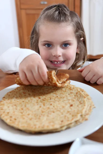 Bedårande liten flicka äta crepes — Stockfoto