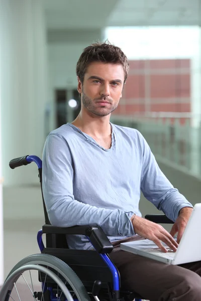 Hombre en portátil en silla de ruedas — Foto de Stock