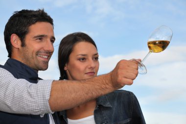 Couple tasting wine outdoors clipart