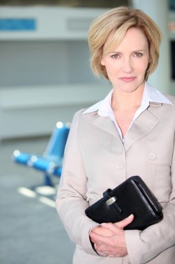 Businesswoman waiting at airport clipart