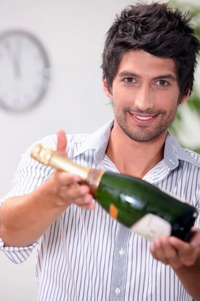 Un uomo che offre una bottiglia di champagne . — Foto Stock
