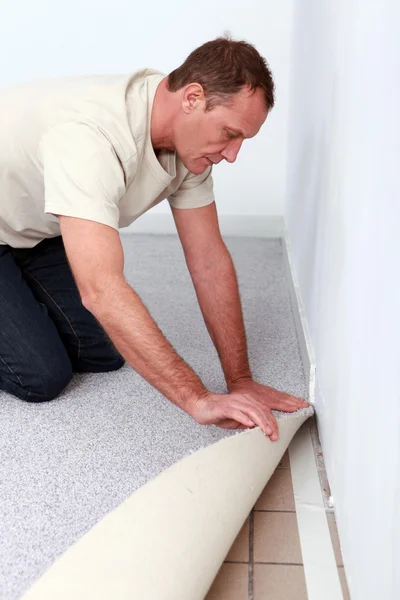 Handyman está colocando alfombra ajustada — Foto de Stock
