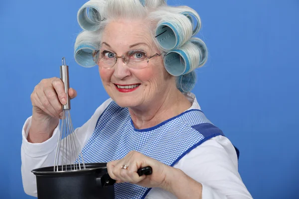 Granny cooking with her hair in rollers — Stock Photo, Image