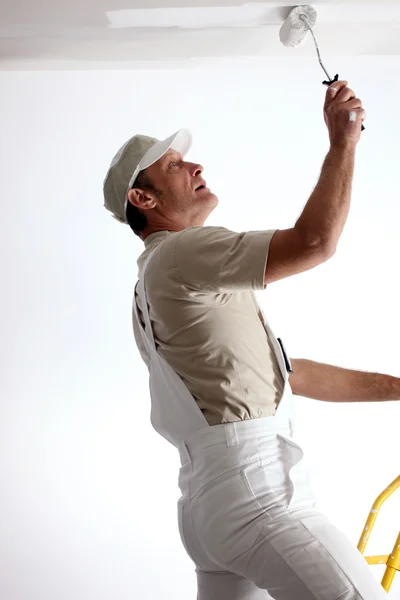 Man repainting ceiling with roller — Stock Photo, Image