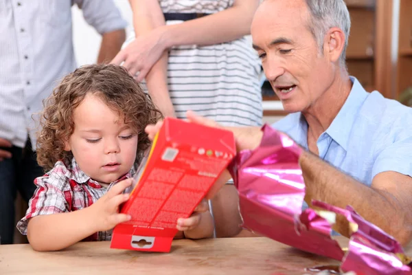 Menino abrindo um presente de seu avô — Fotografia de Stock