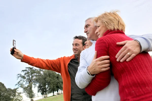 Family taking their own picture with a phone — Stock Photo, Image