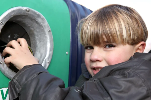Liten pojke kastar en glasflaska i en behållare — Stockfoto