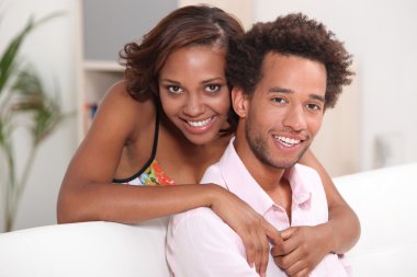 African couple relaxing at home clipart