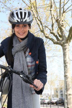 Woman riding a bike in the city clipart