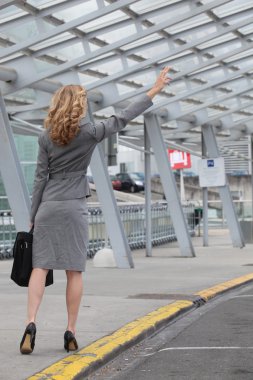 Businesswoman stopping taxi clipart