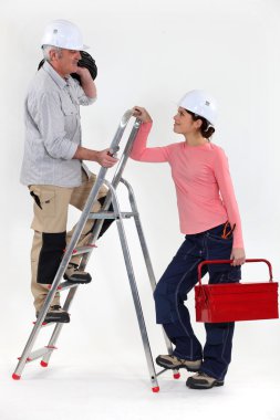 Craftsman working with his female apprentice clipart