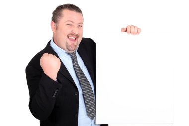 A successful businessman holding up a blank sign clipart